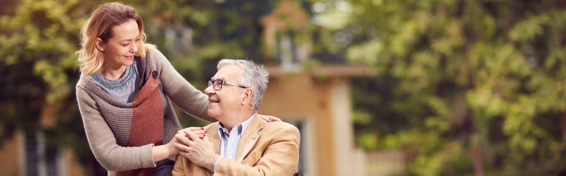 Senior men in wheelchair with happy caregiver daughter